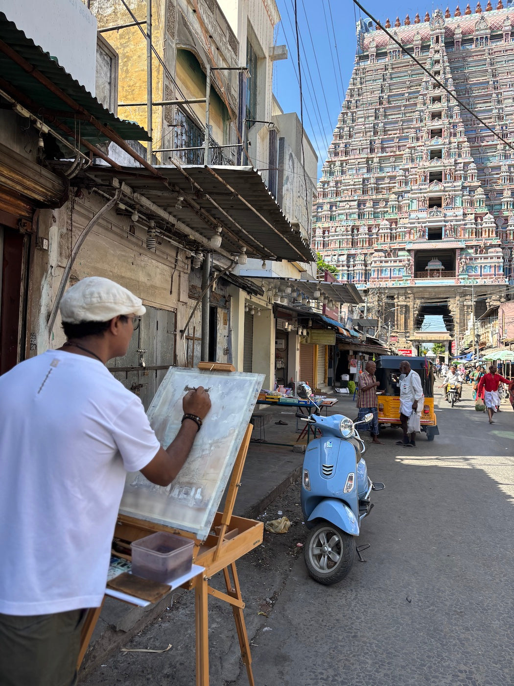 Nitin Singh watercolor artist painting on a street with a temple in the background